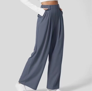 Dettaglio macro dei pantaloni a gamba larga a vita alta con tessuto drappeggiato