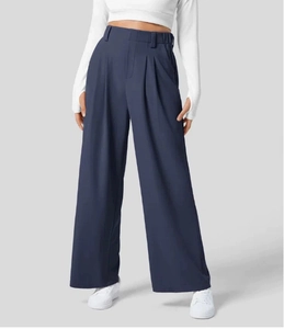 Dettaglio dei pantaloni a gamba larga a vita alta in tessuto drappeggiato blu navy e pieghe