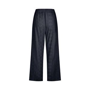 Detail of black drawstring cropped pants showing elastic waist and textured fabric