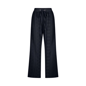 Detail of black high-waisted drawstring pants featuring luxury floral jacquard patterns