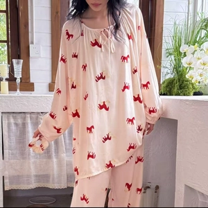 Detailed close-up of pink printed cotton silk pajamas with floral bow tie and lantern sleeves