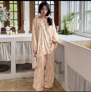 Detail of floral printed cotton pajama set featuring lace-up collar and lantern sleeves