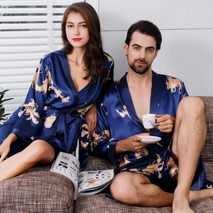 Matching navy blue silk satin couple robes with golden dragon prints in a home setting