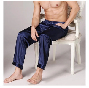Detail of navy blue satin men's pajama pants with elastic waist and black piping trim