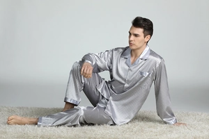 Detailed view of men's satin pajama set featuring grey geometric print and contrast piping
