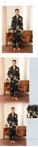 Detail of men's black silk-like robe set featuring golden dragon patterns and side pockets