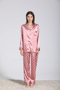 Dettaglio pigiama in raso di seta rosa a pois con profili a contrasto e colletto a camicia