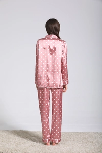 Détail du pyjama en soie à pois roses montrant le poignet et la texture du satin