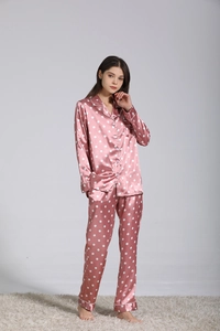 Détail de l'ensemble de pyjama en soie rose à pois blancs et design à manches longues