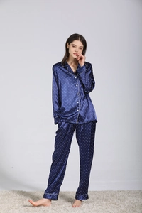 Dettaglio del pigiama in seta blu navy da donna con profili bianchi e motivi a cuore