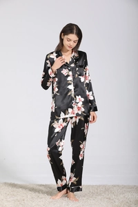 Détail de pyjama en satin noir à fleurs blanches avec bordures contrastées blanches