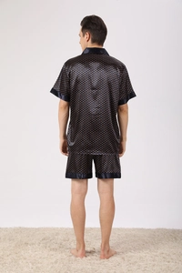 Détail du pyjama pour homme en satin avec des pois dorés sur un tissu bleu marine foncé