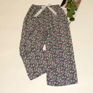 Detail of floral wide-leg sleep pants with purple print and a white ribbon bow tie