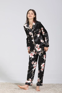 Détail d'un pyjama en soie noire pour femme avec imprimé floral et liseré blanc chic