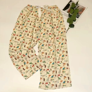 Detail view of cartoon print pajama pants featuring a decorative white silk bow on the waist
