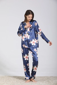 Détail de pyjama en satin soyeux avec imprimé orchidée et passepoil blanc contrastant