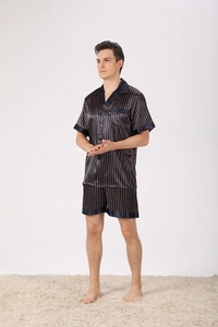 Pyjama en satin bleu marine pour hommes avec fines rayures dorées sur un tapis blanc