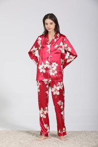 Dettaglio del set pigiama in raso rosso con stampe floreali indossato da una modella