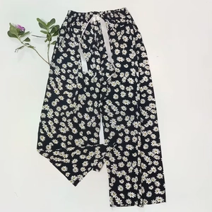 Detail of white daisy floral print pajama pants with elastic waist and satin drawstring