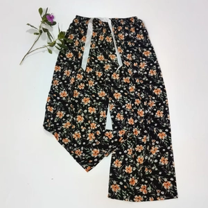 Detail view of floral cotton lounge pants featuring adjustable waist drawstring and wide leg cut