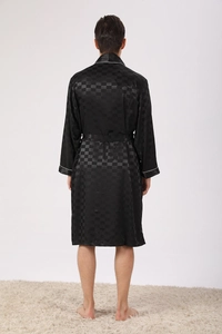 Detail of men's black silk robe with jacquard pattern and white piped cuffs
