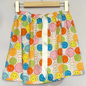 Details der bunten Smiley-Blumen-Shorts mit elastischem Bund und weißer Seidenschleife