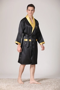 Detail of premium black silk bathrobe with golden crown embroidery and satin finish