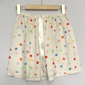 Detailaufnahme der weißen Baumwoll-Shorts mit bunten Punkten und einer feinen Satin-Schleife