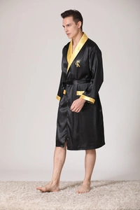 Detail of black silk robe with golden crown embroidery and contrast trim on pocket
