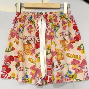 Detail der hellrosa Schlafshorts mit Blumendruck und einem weißen Kordelzug aus Satin