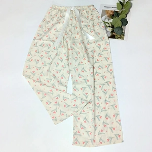 Detail of floral sleep pants featuring elastic waistband with a white satin ribbon tie