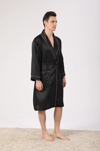 Detail of black silk satin robe featuring white contrast piping and striped texture