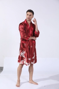 Detail view of men's red satin silk bathrobe featuring traditional white crane print