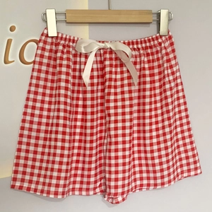 Detail von rot-weiß karierten Baumwollshorts mit elastischem Bund und dekorativer Schleife