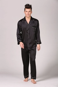 Close-up of black silk men's pajama set with white piping details and classic buttons