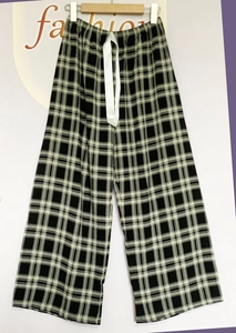 Detail of checkered sleep pants with elastic waist and white ribbon drawstring