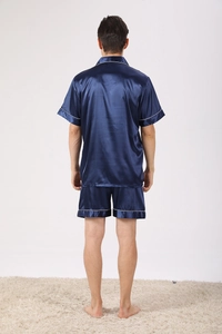 Rear view of navy blue silk pajamas set with white piping on loose short sleeves