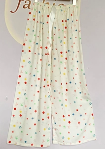 Detailed view of elastic waist and white satin drawstring on colorful polka dot sleep pants