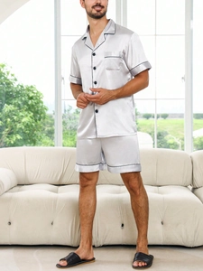 Close-up of silver-gray satin men pajama set with black piping and button-down shirt detail