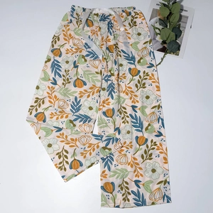 Detail of floral sleep pants with yellow flowers and white satin drawstring waist