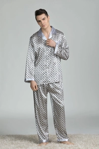 Men's silk-like pajama set with geometric patterns on plush carpet in a home setting
