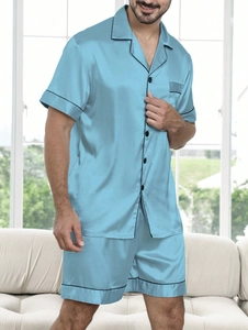 Detail of light blue satin men's pajama set with black contrast piping and buttons