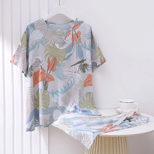 Detail of grey short sleeve pajama set featuring vibrant tropical leaf prints and V-neckline