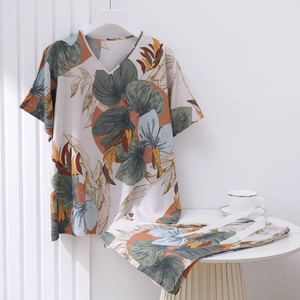 Detail of tropical leaf print pajamas set with V-neck top and matching pants