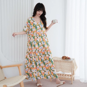 Dettaglio dell'abito maxi a fiori con scollo a V e gonna a balze per le vacanze
