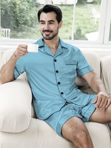Close-up of sky blue satin men's pajamas set with black piping and high silk-like luster