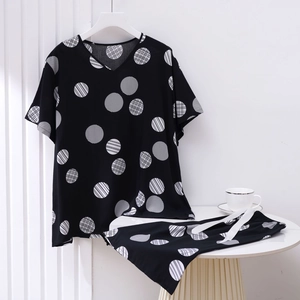 Detail of V-neck pajamas set with black and white polka dot pattern on soft cotton fabric