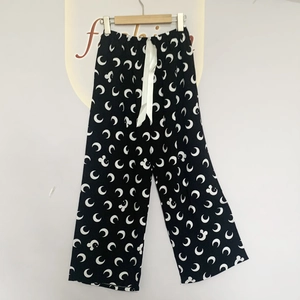 Detail view of cotton pajama pants with moon print and adjustable silk ribbon waist