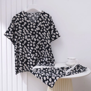 Detail view of V-neck daisy print pajamas set in black cotton with yellow floral pattern