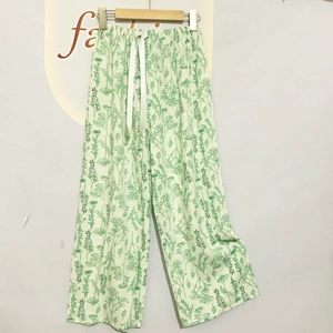 Detail view of cotton floral lounge pants with elastic drawstring waist on a wooden hanger